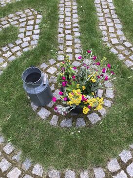 Mit Blumen geschmückte Mitte eines gepflasterten Labyrinthes.