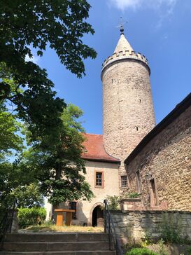 Der Turm der Leuchtenburg bei blauem Himmel.