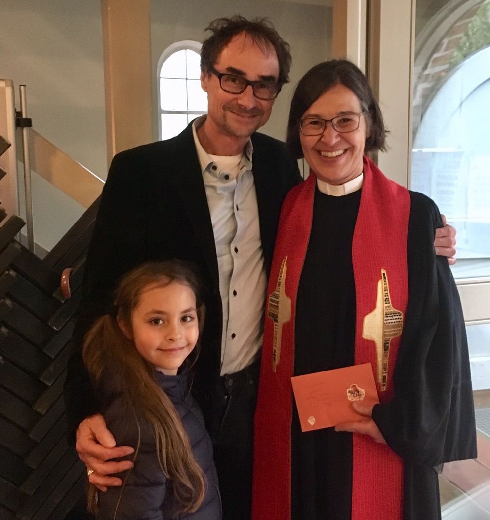 Die Pastorin, Frank Hofmann und seine Tochter stehen nah beieinander in dem Kirchenraum.