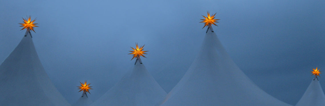 Weiße Zeltspitzen mit leuchtenden Sternen an der Spitze