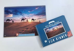 Beide Adventskalender (Der Andere Advent und Der Andere Advent für Kinder) liegen auf einem weißen Untergrund.