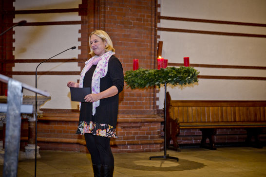 Iris Macke steht im Altarraum vor dem Adventskranz