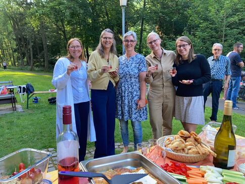 Das Andere Zeiten-Team mit Uschigrab hinter einem Buffettisch auf einer Wiese.