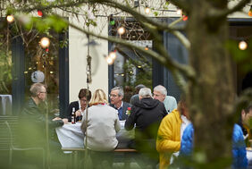 Menschen sitzen an einem Tisch im Garten