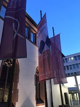 Die Flagge des Katholikentags in Stuttgart vor dem Hospitalhof im Abendlicht