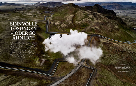 Das Foto zeigt eine Luftaufnahme einer hügeligen Landschaft, die von einer Straße und vielen Leitungen durchzogen ist.