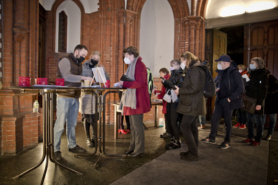 Gottesdienstbesucher registrieren sich am Eingang der Kirche