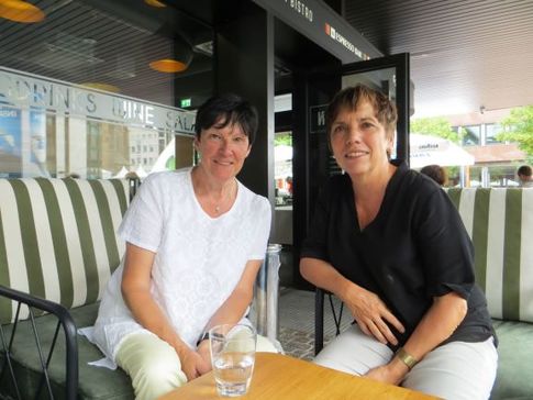 Leserin Ute Mayer sitzt mit Margot Käßmann an einem Tisch, beide schauen in die Kamera.